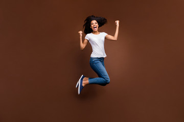 Fototapeta na wymiar Full length photo of funny wild dark skin lady jumping high incredible feelings emotions attend football match wear casual white t-shirt jeans isolated brown color background