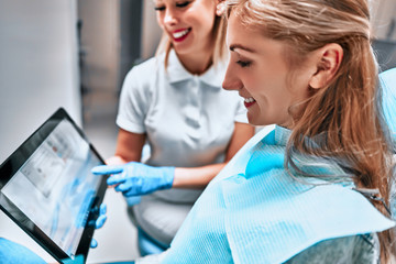 Obraz premium Female dentist with digital tablet. Modern treatment in professional dental clinic.