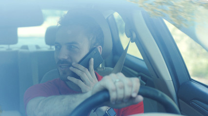 Portrait smiling young handsome happy man use phone in the car look at camera driver mobile automobile cell drive hand smartphone auto business communication traffic businessman telephone