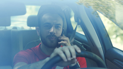 Portrait smiling young handsome happy man use phone in the car look at camera driver mobile automobile cell drive hand smartphone auto business communication traffic businessman telephone