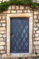 Antique wooden door covered with metal strips, Croatia lock