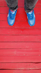 blue sneakers on a red wooden bridge