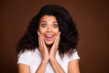 Close up photo of crazy amazed afro american girl hear incredible bargain news scream touch palms cheeks wear casual style outfit isolated over brown color background