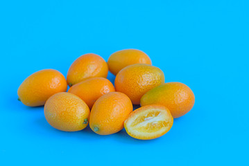 ripe kumquat on a blue background, exotic citrus fruits