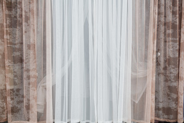 Obraz na płótnie Canvas Curtains and tulle in a modern interior. Various decorative fabric materials for the home. Modern vision of style. The combination of colors and aromas. decoration of windows in the room
