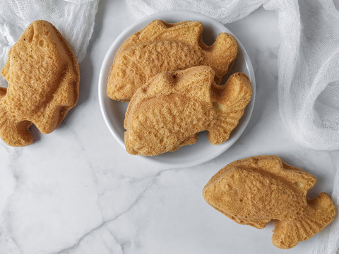 Flatlay styling of baulu cakes in the form of goldfish. A malay called kuih bahulu.