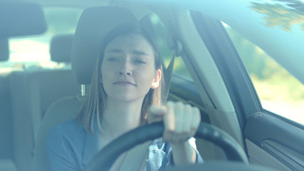 Portrait of beautiful young woman driving car smile look around through big sunny face automobile road travel attractive emotional enjoyment freedom holiday moving outdoors slow motion