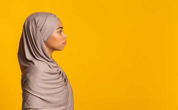 Profile Portrait Of Black Muslim Woman In Hijab Over Yellow Background