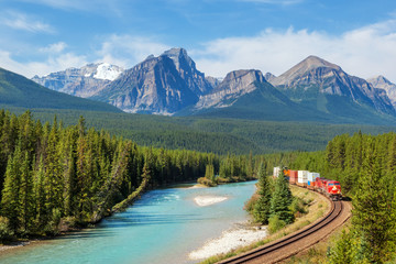 Freight train moving along Bow river in Rocky Mountains range, Canada - 318859154