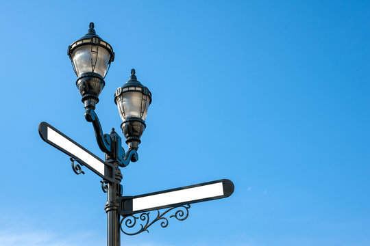 Antique iron streetlight with blank street names on the crossroads in Hoboken, New Jersey, USA