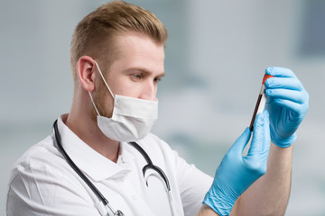 Scientist with medical face mask and blood probe