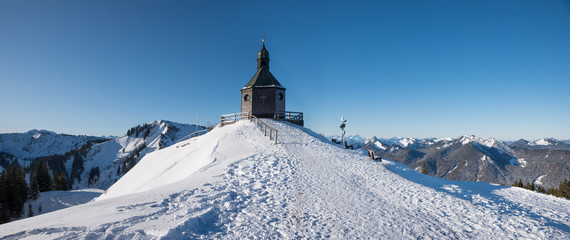 Fototapeta na wymiar beautiful chapel in winter landscape, popular tourist destination with view to bavarian alps