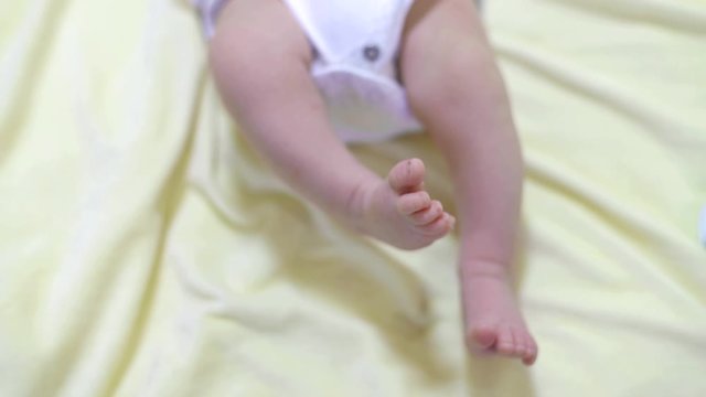 Feet of a small child. The child twitches its legs while lying down.