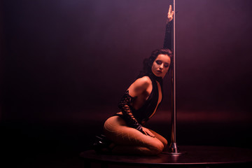 beautiful stripper dancing near pylon on black with copy space