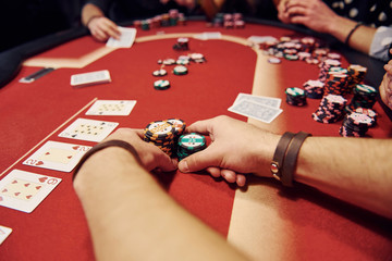 Group of elegant young people that playing poker in casino together