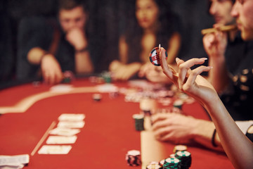 Group of elegant young people that playing poker in casino together