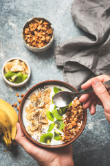 Healthy fruit granola bowl with yogurt. Clean eating, healthy lifestyle, vegetarian diet concept. Yogurt with banana, kiwi, chia seeds and crunchy honey granola