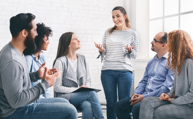 Woman sharing her progres with group on therapy session in rehab