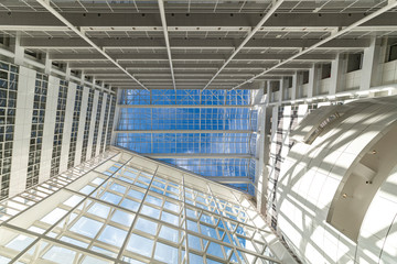 Abstract up view of a white building toward a pur blue sky with small white clouds