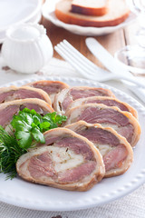 Cooked pork knuckle roll with chicken on a white plate, selective focus