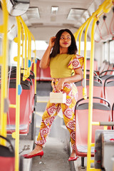 Young stylish african american woman riding on a bus.