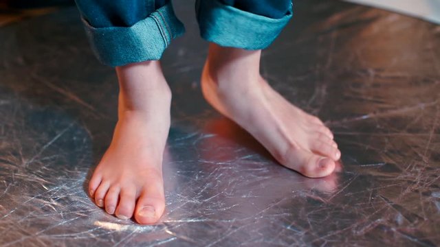 A closeup of the feet of a boy doing foot movements.