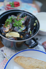 Mussels in a cauldron with cream sauce and herbs. Bar of mussels. Dinner with a beer. Dinner with vermouth.