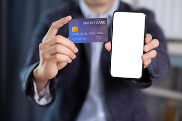 Man hand holding blank screen smartphone and credit card wear suit jacket