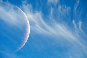 Crescent moon and white clouds. The moon against the blue sky. Screensaver on your desktop.