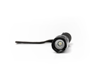 Small black pocket lamp on a white background. Turned off flashlight close-up on a light background.