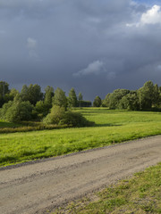 storm clouds over sunny field