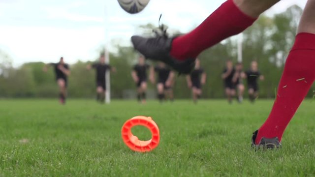 Scoring a conversion with a Rugby Kick. A player is kicking the ball during a match through the rugby posts. Super Slow motion. Close up