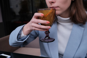 Woman drink hot orange tea in coat.