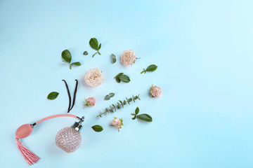 Beautiful composition with bottle of perfume and flowers on white background, flat lay. Space for text