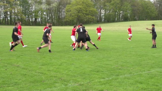 Rugby Match Action. Open play outdoors on a grass pitch. Players fighting for the ball.
