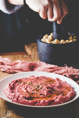 Home made hummus plate , decorated with boiled , herbs, and olive oil on dark background