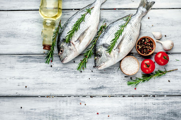  Fresh dorado fish with spices and ingredients for cooking on a wooden table background with copy...