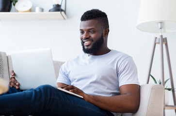 African soft developer programming code on laptop