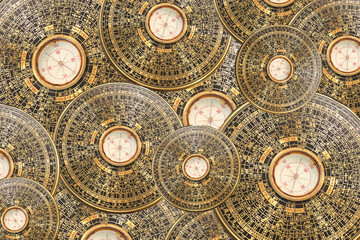 The artistic pattern from old vintage asian compasses used in feng shui, blurred, many golden items with copy space for any text.