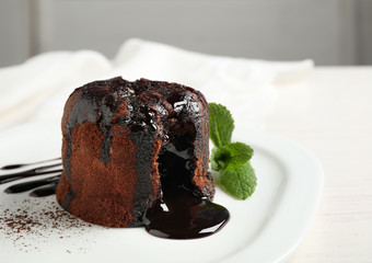 Delicious warm chocolate lava cake on plate, closeup