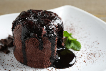 Delicious warm chocolate lava cake on plate, closeup