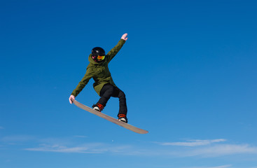 Fototapeta na wymiar Snowboarder jumping high in the air