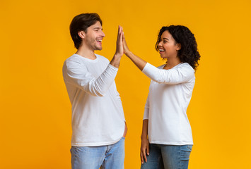 White Guy And Black Girl Giving High-Five To Each Other