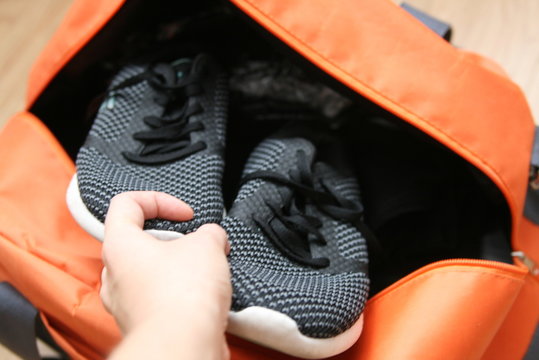 Puts Sneakers In A Sports Bag, Preparing Things For Training