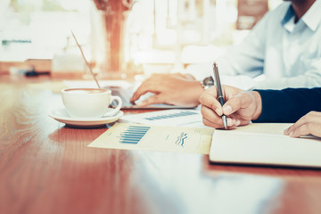 Businessman hand writing note on a notebook. Business man working at office desk.