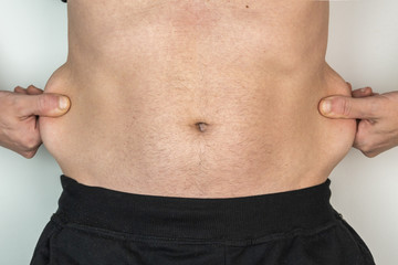 Naklejka premium Slim Caucasian man with abdominal fat, isolated on white background