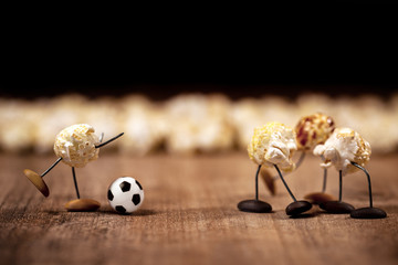 cute funny popcorn figures are playing soccer, football or soccer scene
