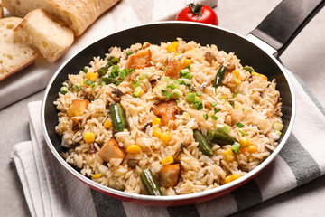 Delicious rice pilaf with vegetables on table