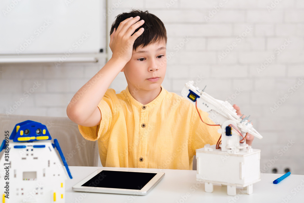 Poster Schoolboy creating robot at class, making mistake