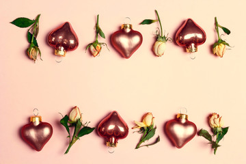 Frame of decorative hearts and little roses on a pink background.